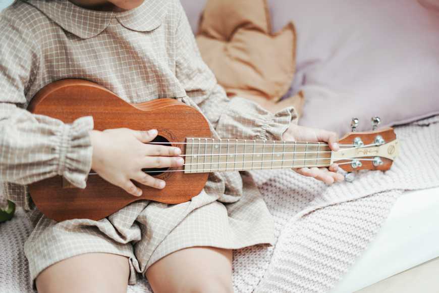 a girl holding brown ukulele 3662750